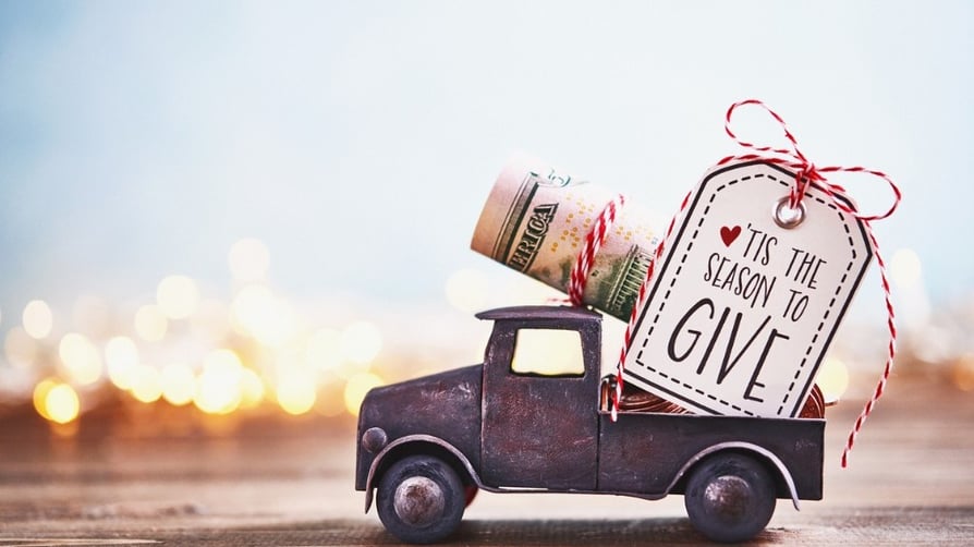 season-to-give-truck-carrying-roll-of-dollars-with-holiday-background-picture-id1166729754 FB